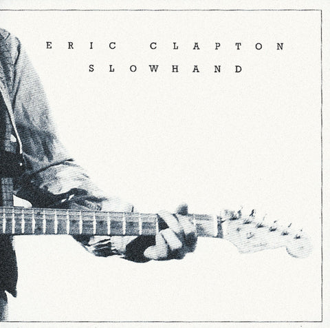 Black and white album cover of 'Slowhand' by Eric Clapton featuring Clapton playing guitar.