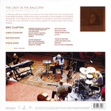 Back cover of a music album featuring Eric Clapton and his band performing in a studio setting.