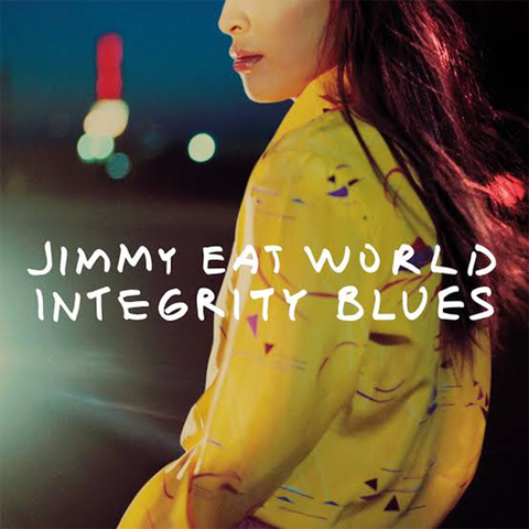 Cover art showcases a close-up of a woman, in a vibrant yellow top against a blurred backdrop of a cityscape at dusk.