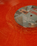 Red vinyl record with a gray label featuring text and images.