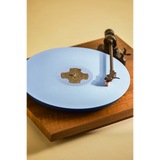 Blue Vinyl on a wooden turntable with a beige background