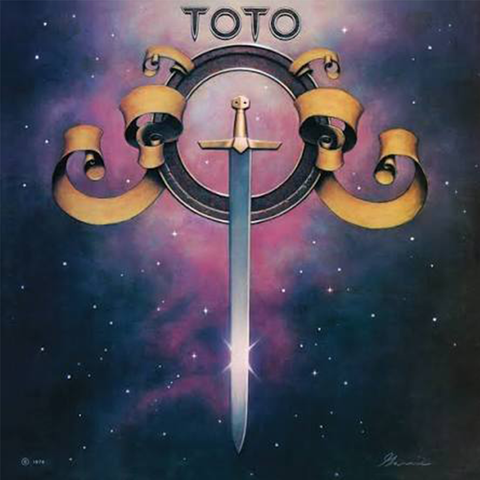 Toto album cover artwork featuring a vertical silver sword centered within a circular emblem, flanked by gold ribbon-like forms, set against a starry purple and blue cosmic background. The word 'TOTO' appears at the top.