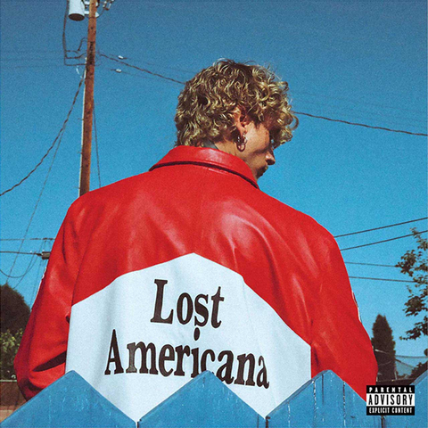 MGK wearing a red jacket with 'Lost Americana' text against a blue sky.
