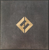 A muted gray background with a prominent, stylized "F" logo in a golden hue positioned centrally within a diamond shape.