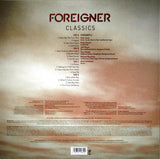 The image shows the back cover of the 'FOREIGNER - CLASSICS' album, featuring a red skyline and track listing