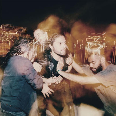 A photo of Gang of Youths members during a live performance, with stage lights and effects contributing to the ambiance.