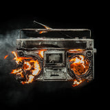 A stylized image of a burning boombox with flames and smoke, representing the Green Day album 'Revolution Radio'.