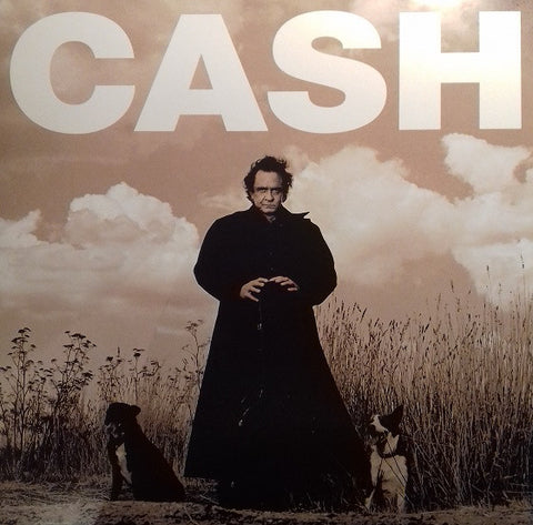 The cover of the 'American Recordings' album by Johnny Cash, featuring a photograph of Cash standing outdoors with a dog by his side, against a backdrop of a cloudy sky and tall grass. The album title is prominently displayed in large white letters at the top.