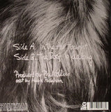 Phil Collins In The Air Tonight Back Cover with an image of the back of Phil’s Head with track listing in white text