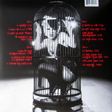 This product image features the Back cover art for P!NK's album "Try This." The artwork utilises a striking black and white photograph of P!NK in a bird cage with album track listing in Bold Red