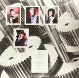 Images of Queen Band members on a cogs of a machine image background and track listing insert
