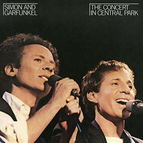 Cover art for Simon & Garfunkel's album 'The Concert in Central Park' featuring photographs of the artists singing into microphones.