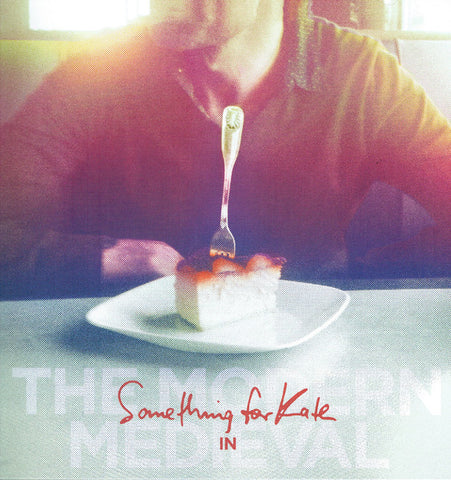 Cover art for 'Something for Kate - The Modern Medieval' featuring a piece of cake on a plate with a fork, against a blurred background.