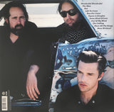 Back Cover featuring 3 band members in a car and a track listing