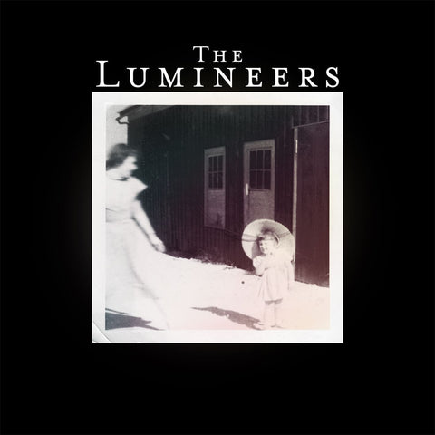 The image features the cover art for 'The Lumineers' album, displaying a monochrome photograph of a person  and child standing outside a house at night, with the band name 'The Lumineers' prominently displayed above.