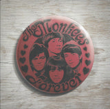 A button with 'The Monkees Forever' text and images of the band members' faces.